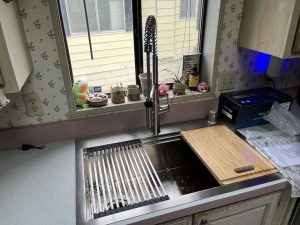 Kitchen workstation sink with a black faucet