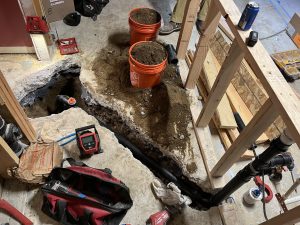 Floor opened and excavated to reach a buried drain line