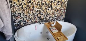 Finished soaking tub with a pebble mosaic surround
